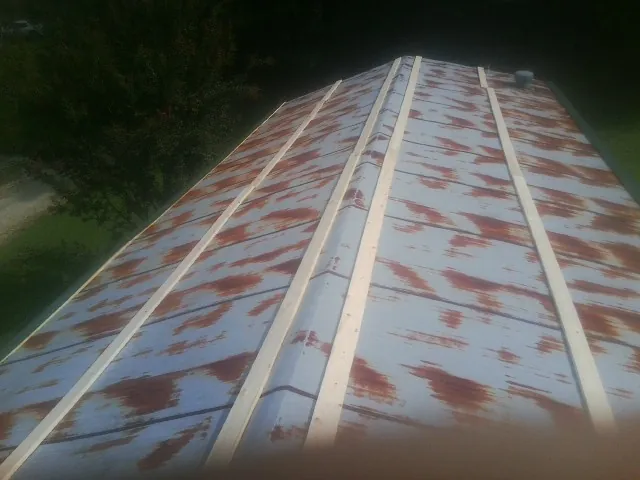 Rusted metal roof panels with new wood purlins before replacement — Storm Damage Roof Repair in Broadbent by Roofing Brothers